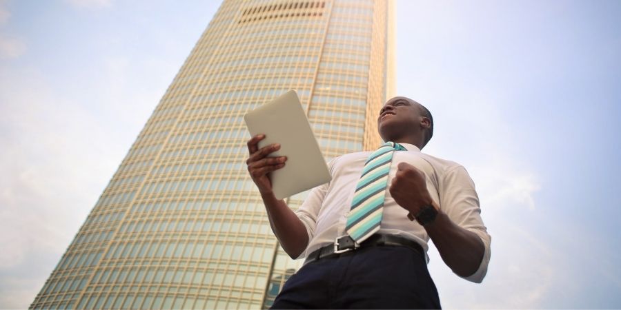 Business leader standing in front of company building